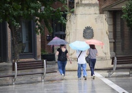 Un grupo de mujeres pasean por el centro de Murcia en un día de lluvia.