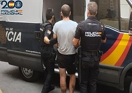 Dos agentes arrestando a uno de los acusados del robo de una caravana.