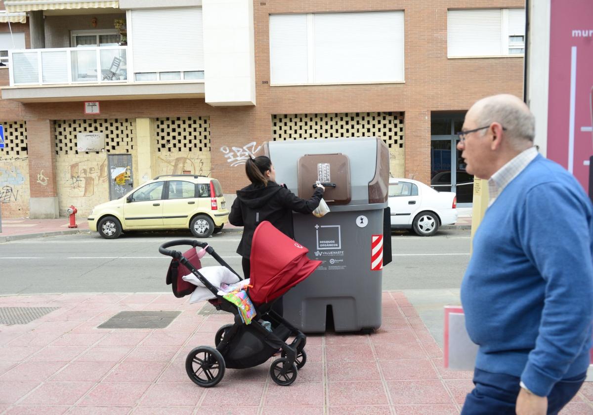 Una mujer utiliza un contenedor marrón instalado de pruebas en Murcia, en una imagen de hace unos años.