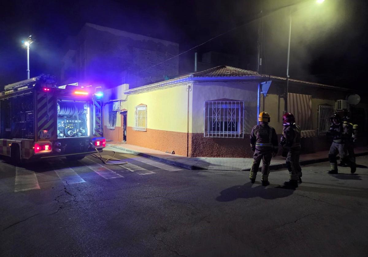 Los bomberos, en la vivienda afectada por el fuego.