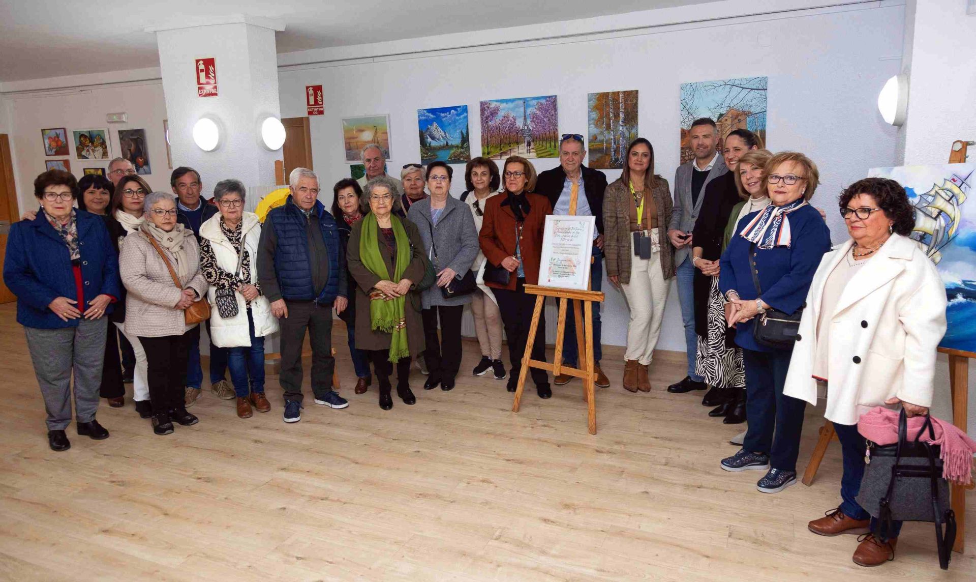 Usuarios del Centro de Personas Mayores posan junto al alcalde en la Sala de Exposiciones.