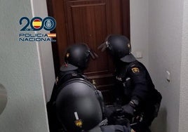 Dos agentes tratan de abrir una puerta para realizar un registro.