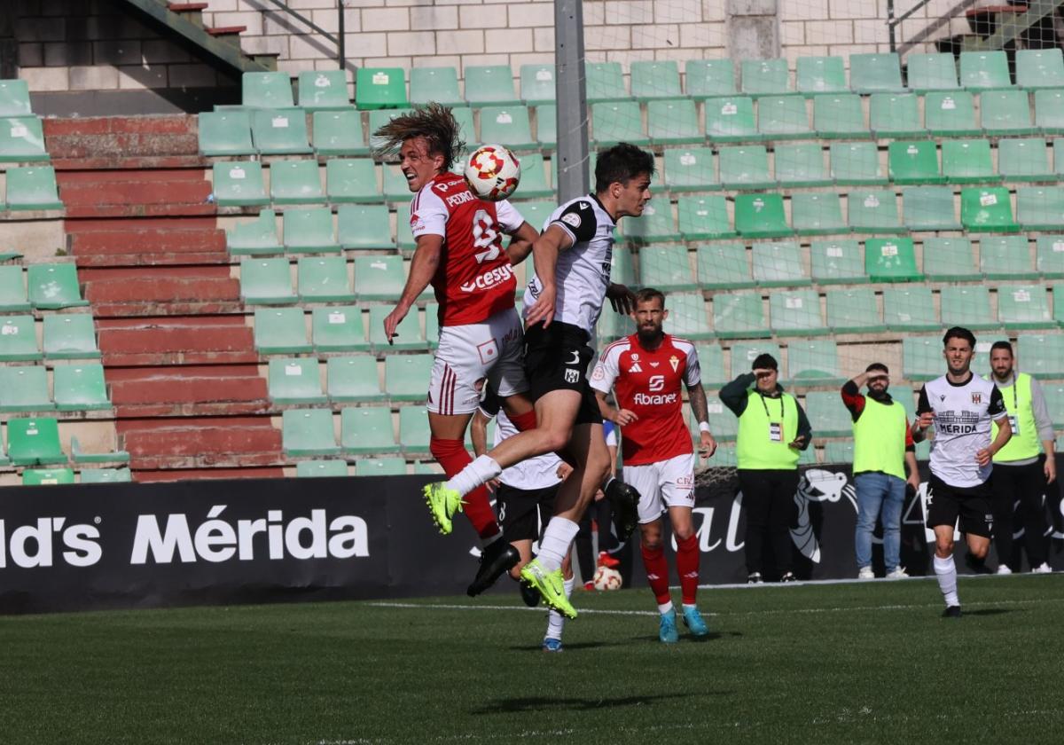 Pedro Benito, jugador del Real Murcia, disputa un balón aéreo con Nil, lateral izquierdo de la AD Mérida.