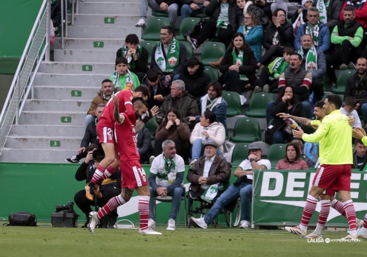 Álex Millán alza los brazos y rompe a llorar en el estadio Martínez Valero, el pasado domingo, mientras sus compañeros lo felicitan por marcar el 0-1, su primer gol en 645 días.