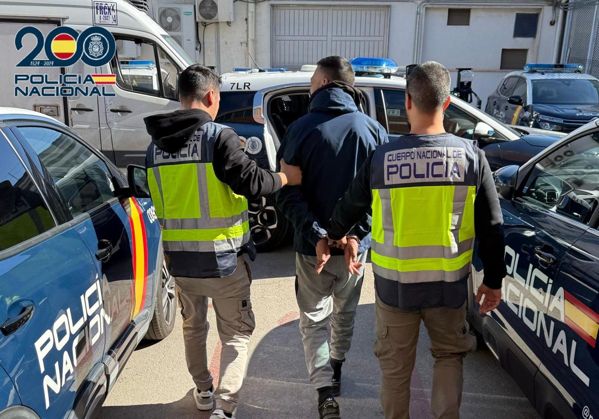 El arrestado junto a dos agentes, en el momento de su detención.