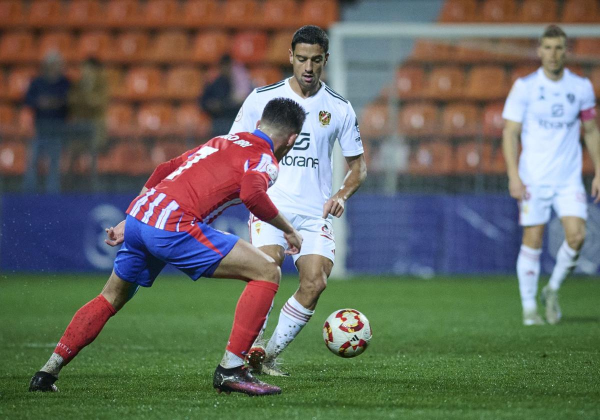 Davo, jugador del Real Murcia, juega el balón ante Diego Bri, del Atlético de Madrid B.