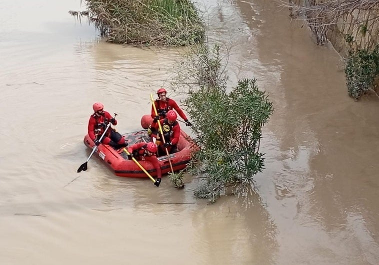 Los bomberos, este lunes, buscando al desaparecido en el río Segura.