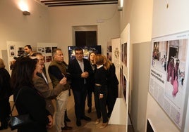 Miembros del paso Morado muestran al alcalde y concejales las fotografías de la exposición.