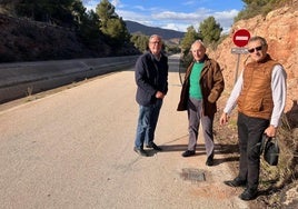 Unos vecinos señalan la placa del primer poste de cierre en el canal que fue cortado en la madrugada de ayer.