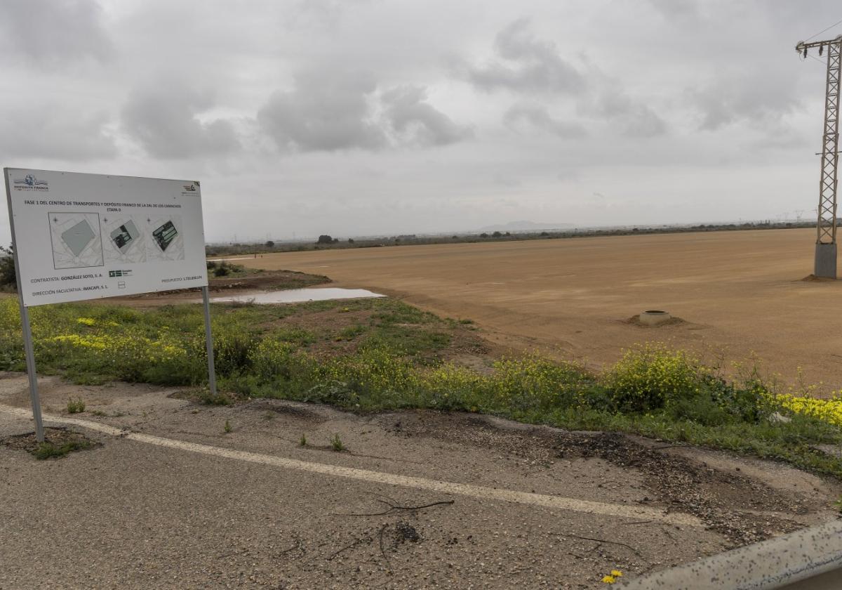 Terrenos donde está prevista la construcción del nuevo Centro de Transportes y Depósito Franco y cartel anunciador de las obras.