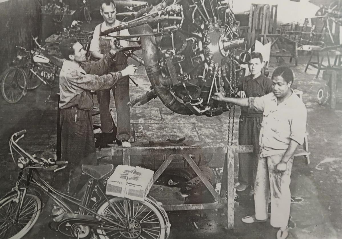 José Frimán y otros empleados manejando un motor de avión, en los talleres de San Javier (década 1950).