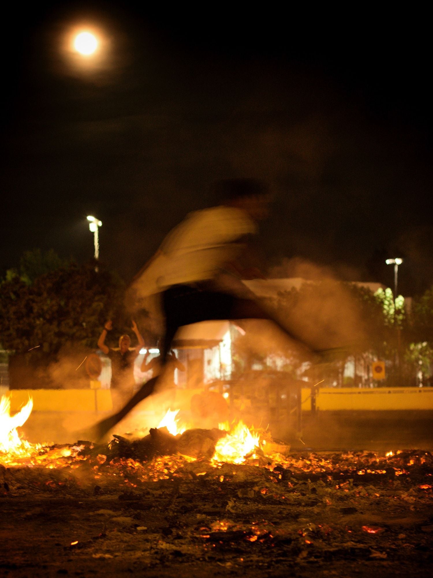 Un joven salta sobre una hoguera en la noche de San Juan, en la pedanía murciana de Puente Tocinos