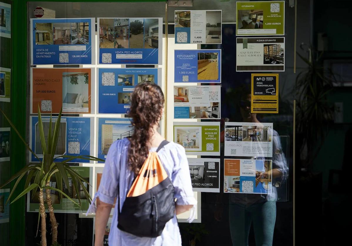 Una joven observa el escaparate de una inmobiliaria, en una foto de archivo.