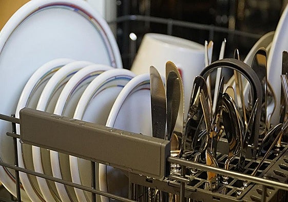 Un lavavajillas lleno de utensilios.
