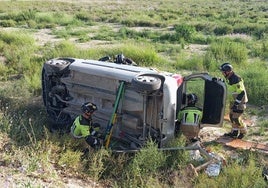 Efectivos de bomberos, junto al coche afectado.