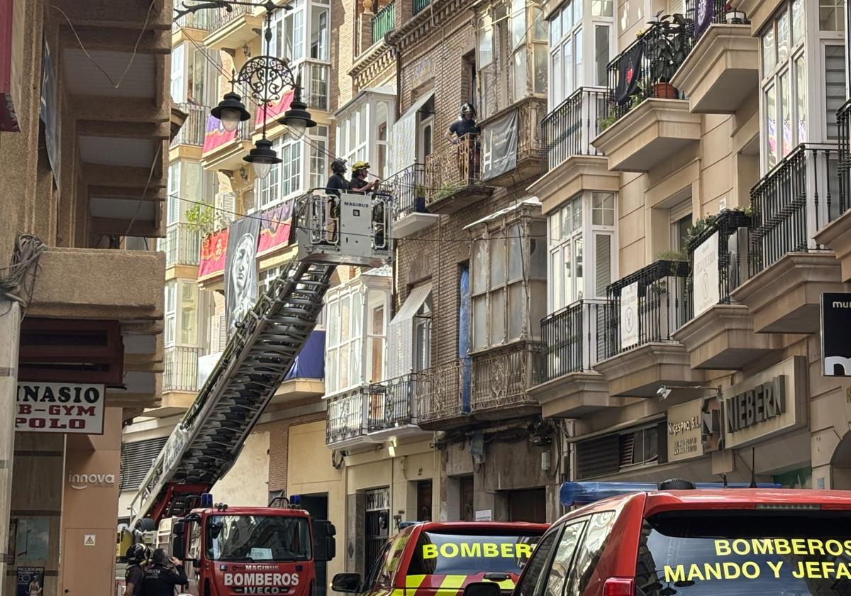 Bomberos aseguran el mirador de un edificio de la calle Jara de Cartagena antes de la procesión del Entierro