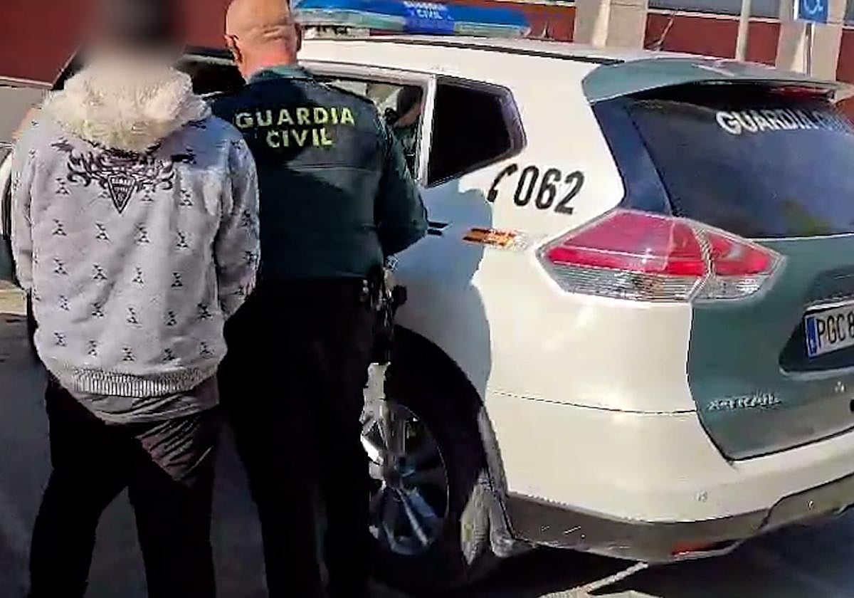 Un agente lleva al detenido hasta el vehículo de la Benemérita.