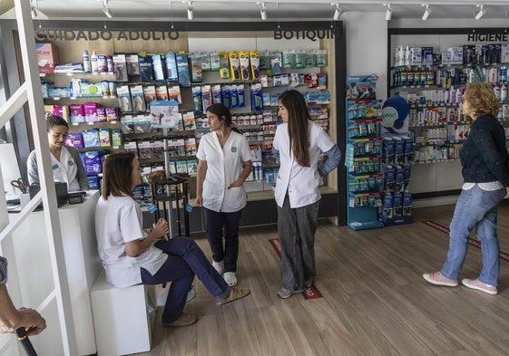 Trabajadoras de una farmacia de Cartagena esperan la vuelta del suministro eléctrico, este lunes.