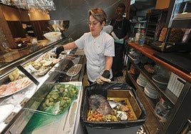 Gina Saltos, jefa de cocina del Salón del Secreto, ayer, tirando pescados y mariscos.