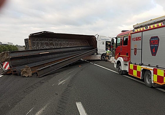 Un vehículo de bomberos, junto al camión volcado.