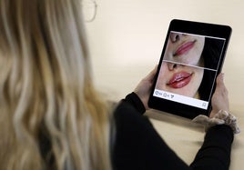 Una joven consulta el anuncio de una clínica de medicina estética.