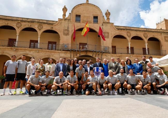 Foto de familia del alcalde de Lorca, Fulgencio Gil, junto a directivos, técnicos y jugadores del Lorca Deportiva, frente al Ayuntamiento.