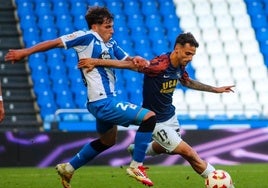 Alexis, del UCAM, intenta deshacerse de Garrido en el choque de ayer disputado en Riazor.