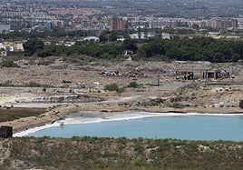 Una de las balsas de residuos peligrosos de Zinsa llena de agua; detrás, escombros de la demolida factoría Española del Zinc.