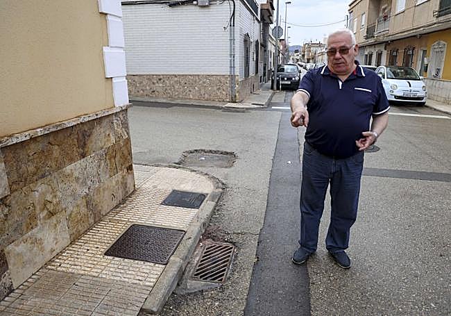 El presidente vecinal muestra arquetas hundidas.