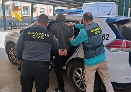 La Guardia Civil introduce en el vehículo a uno de los detenidos.