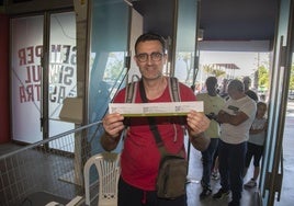 Un aficionado recoge ayer tres entradas, con la cola al fondo.