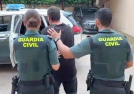 Los agentes conducen al detenido a un vehículo.