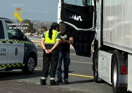 Un agente de la Guardia Civil hablando con el camionero.