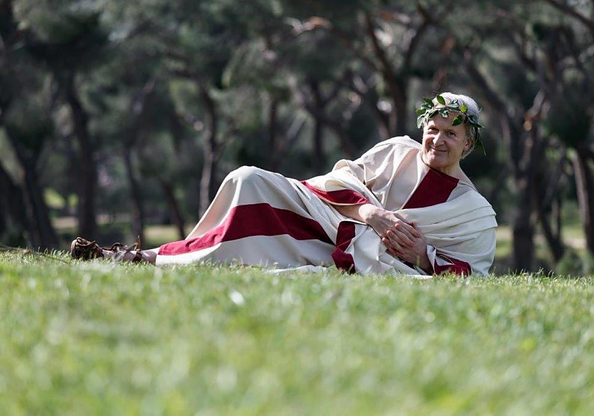 Emilio del Río, tumbado en el césped de la Dehesa de laVilla de Madrid con la togaromana con la que va «habitualmente».