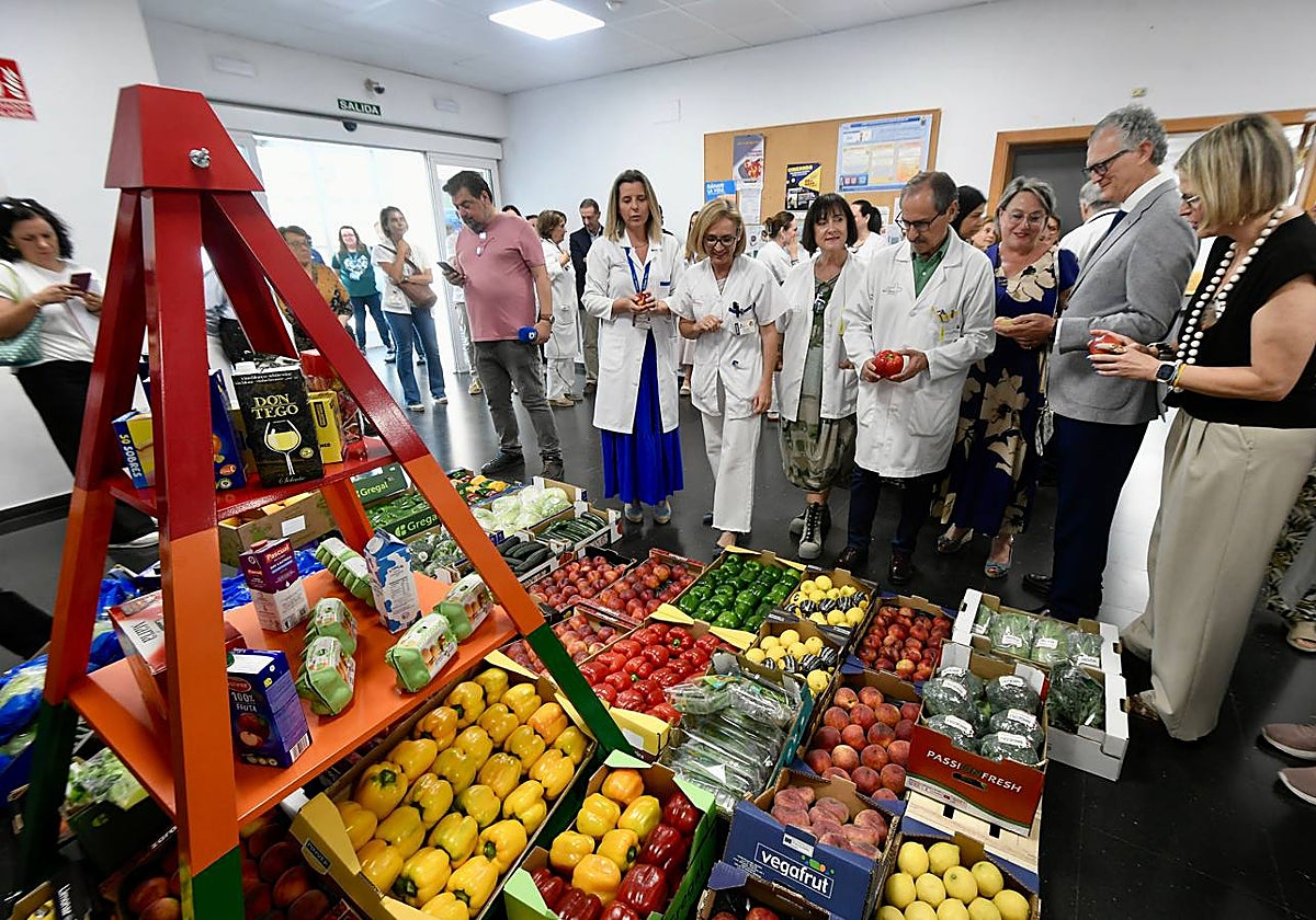 El consejero de Salud, Juan José Pedreño, junto a profesionales sanitarios este martes en el centro de salud de San Andrés, donde se instaló un expositor de frutas donadas por Fecoam.
