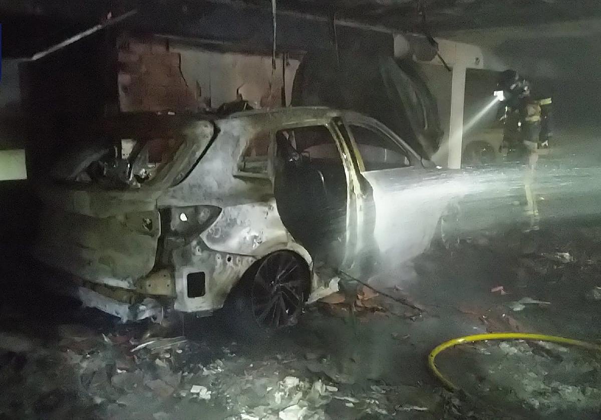 Los bomberos trabajando, este martes, en el concesionario.