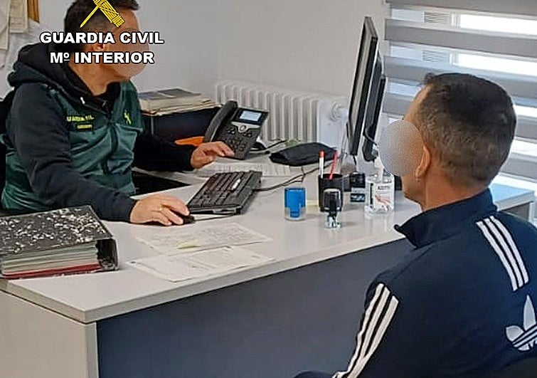 Un agente toma los datos a uno de los detenidos.