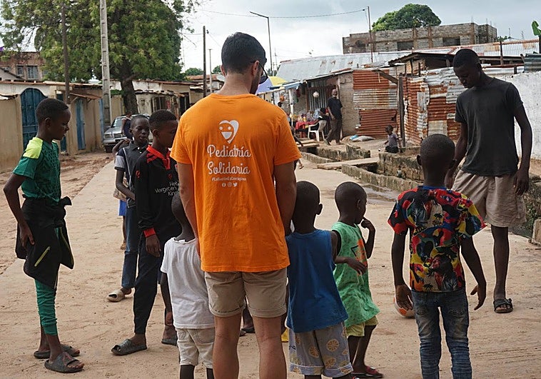 Un voluntario de Pediatría Solidaria juega con unos niños en Faji Kunda, en Gambia, en 2023.