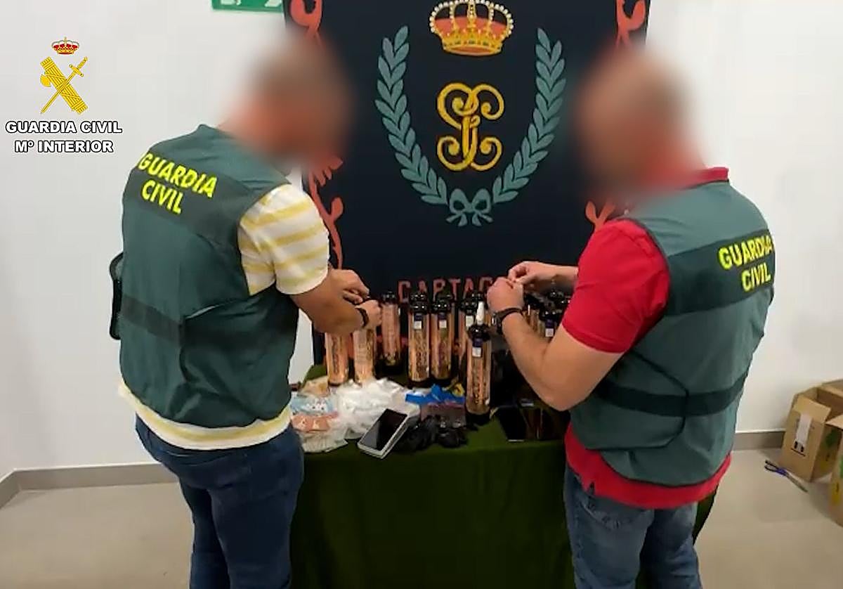 Dos agentes supervisan los objetos incautados.