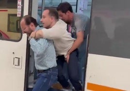 Pablo Molina bajando del tren ayudado por dos personas.