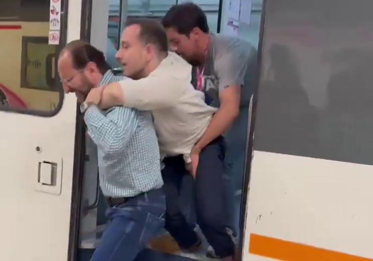 Pablo Molina bajando del tren ayudado por dos personas.