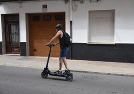 Un hombre protegido con casco circula en patinete, ayer, por una calle de Yecla.