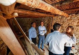 El alcalde, el concejal de Cultura y los arqueólogos durante en el interior de la vivienda que se ha recreado en el parque arqueológico de Los Cipreses