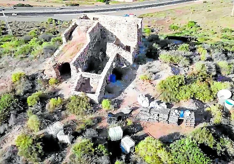 Vista de una de las ermitas del monte Miral, con material de construcción apilado en sus alrededores.