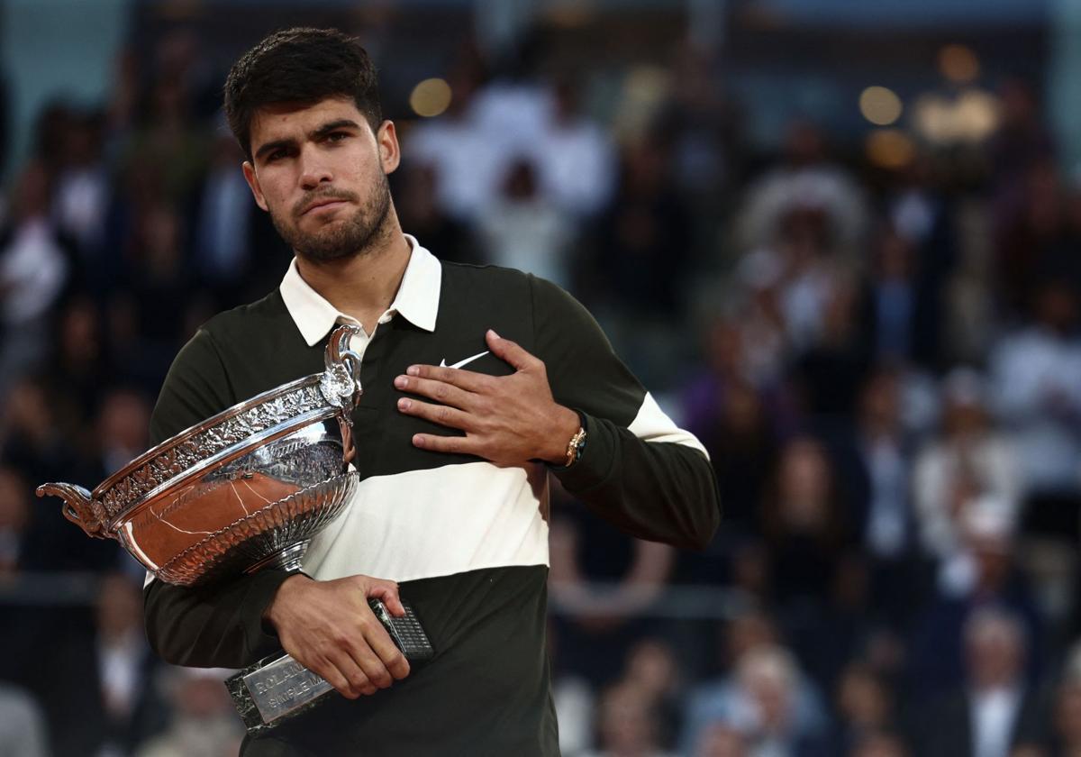Carlos Alcaraz se lleva la mano al corazón después de recibir la Copa de los Mosqueteros que le corona como ganador de Roland Garros.