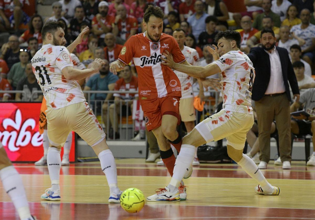 Linhares trata de zafarse de dos jugadores de ElPozo en el partido de este domingo.