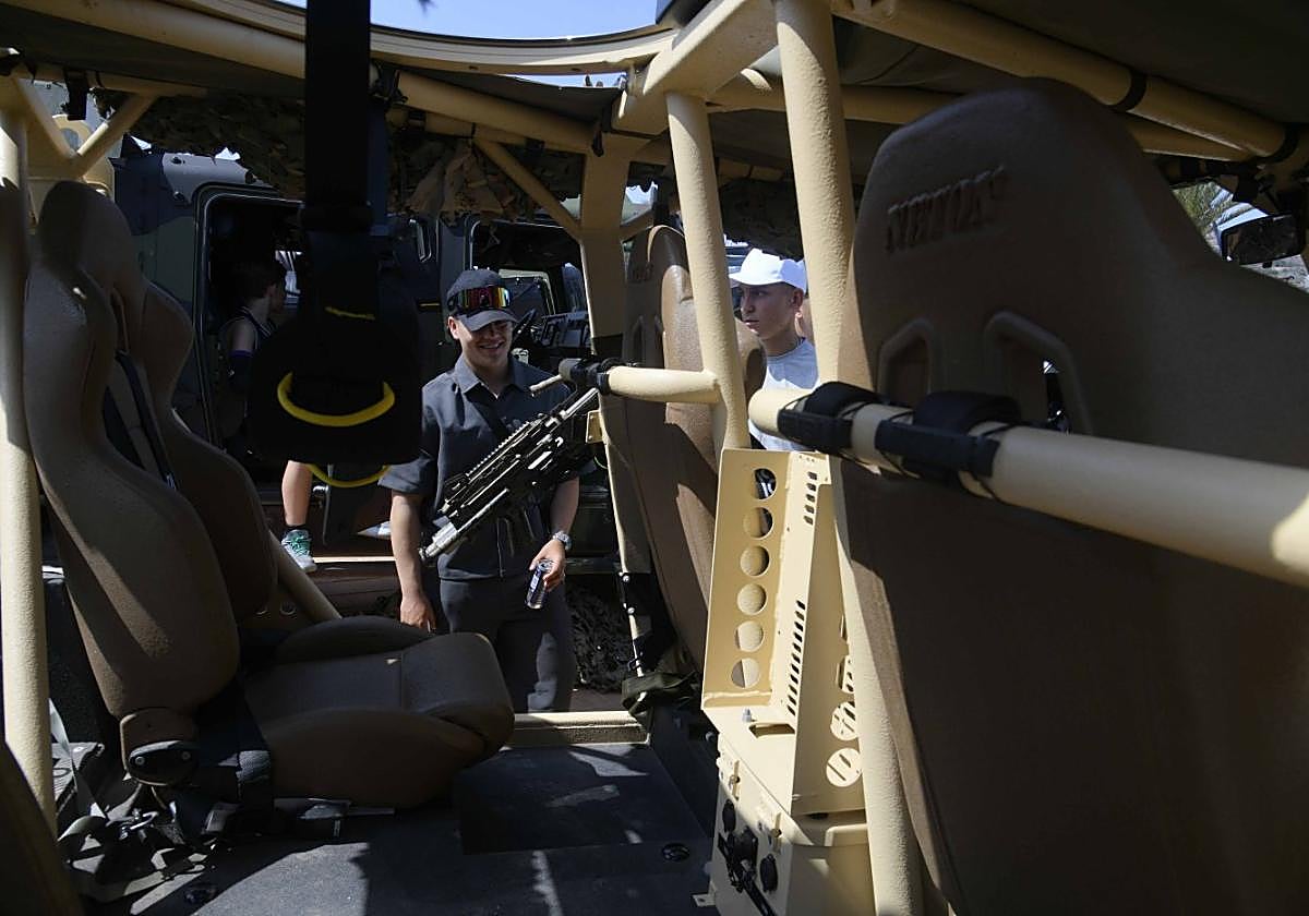 Dos jóvenes observan uno de los vehículos de operaciones especiales de la FGNE.