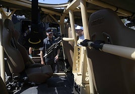 Dos jóvenes observan uno de los vehículos de operaciones especiales de la FGNE.