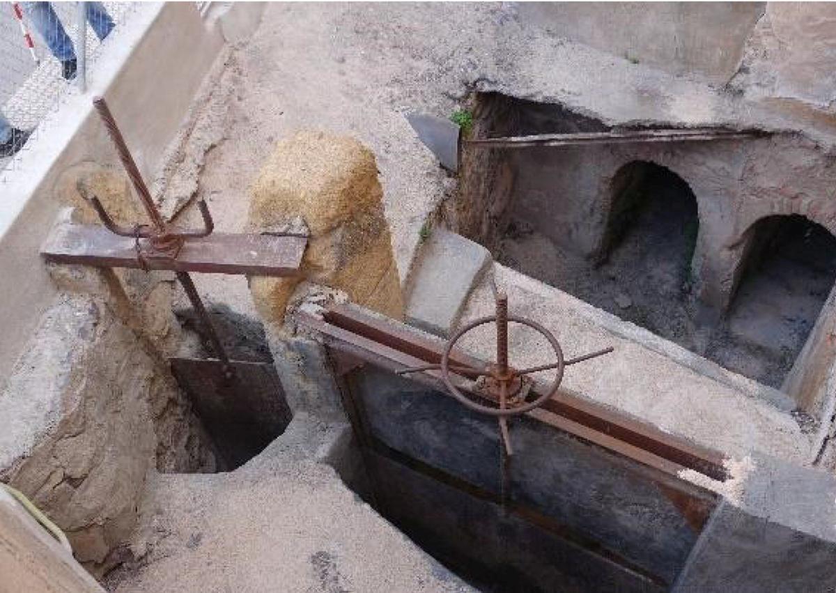 Imagen secundaria 1 - 1. Partidor, a cielo abierto, con el que se regulaba el caudal de agua. 2. Fachada principal del casal del molino, en 1912, con sus trabajadores.