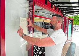 Rodríguez coloca una hoja de firmas en su quiosco.